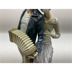 Lladro figure, Sailors Serenade, modelled as a sailor playing an accordion with a woman seated upon a crate, no 5276, year issued 1985, year retired 1988, H32cm