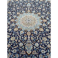 Persian indigo ground rug, the pale blue pole medallion within a field surrounded by scrolling floral decoration with matching spandrels, the thick guarded border with repeating stylised plant motifs within geometric shapes