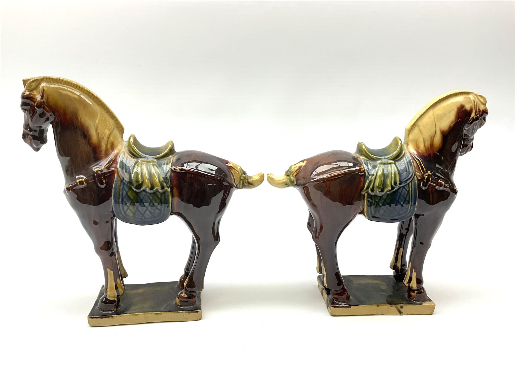 A pair of glazed pottery Tang style horses, each with impressed marks beneath, each approximately H25.5cm. 