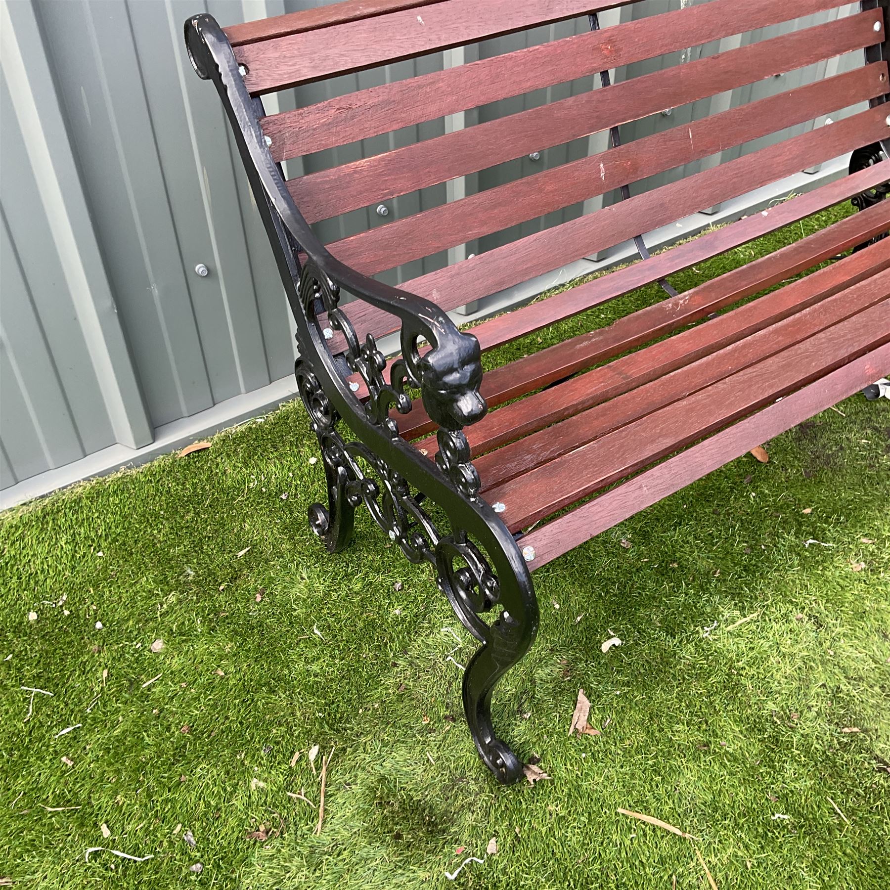 Black painted cast iron and wood slated garden bench decorated with lion heads  - THIS LOT IS TO BE COLLECTED BY APPOINTMENT FROM DUGGLEBY STORAGE, GREAT HILL, EASTFIELD, SCARBOROUGH, YO11 3TX