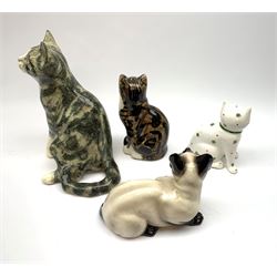 A Winstanley cat, with glass eyes in seated post, signed beneath, H25cm, together with three other figures of cats, including a Rye Pottery example. (4). 