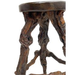 Mid-20th century French grapevine and walnut bow-front wine tasting bar, the curved counter top supported by sculptural grapevine roots, fitted with single shelf and raised on rustic vine feet (W100cm H101cm); with a pair of matching bar stools, the circular top raised on three gnarled root supports united by stretchers (W50cm H70cm)