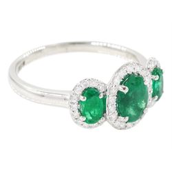 Platinum emerald and diamond trilogy ring, three oval cut emeralds surrounded by round brilliant cut diamonds, hallmarked, total emerald weight approx 1.05 carat, total diamond weight approx 0.25 carat