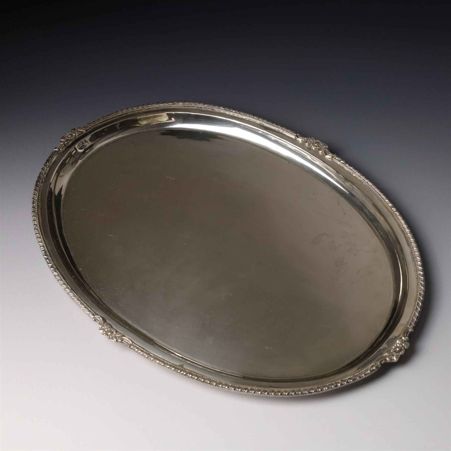 Silver oval tray with gadrooned and floral moulded border W36cm, marked Silver but tests as 800 standard