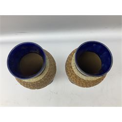 Pair of Royal Doulton Lambeth stoneware baluster vases, decorated in light relief with panels of foliage on blue ground, with gilt scrolls above, impressed mark beneath, 28cm high