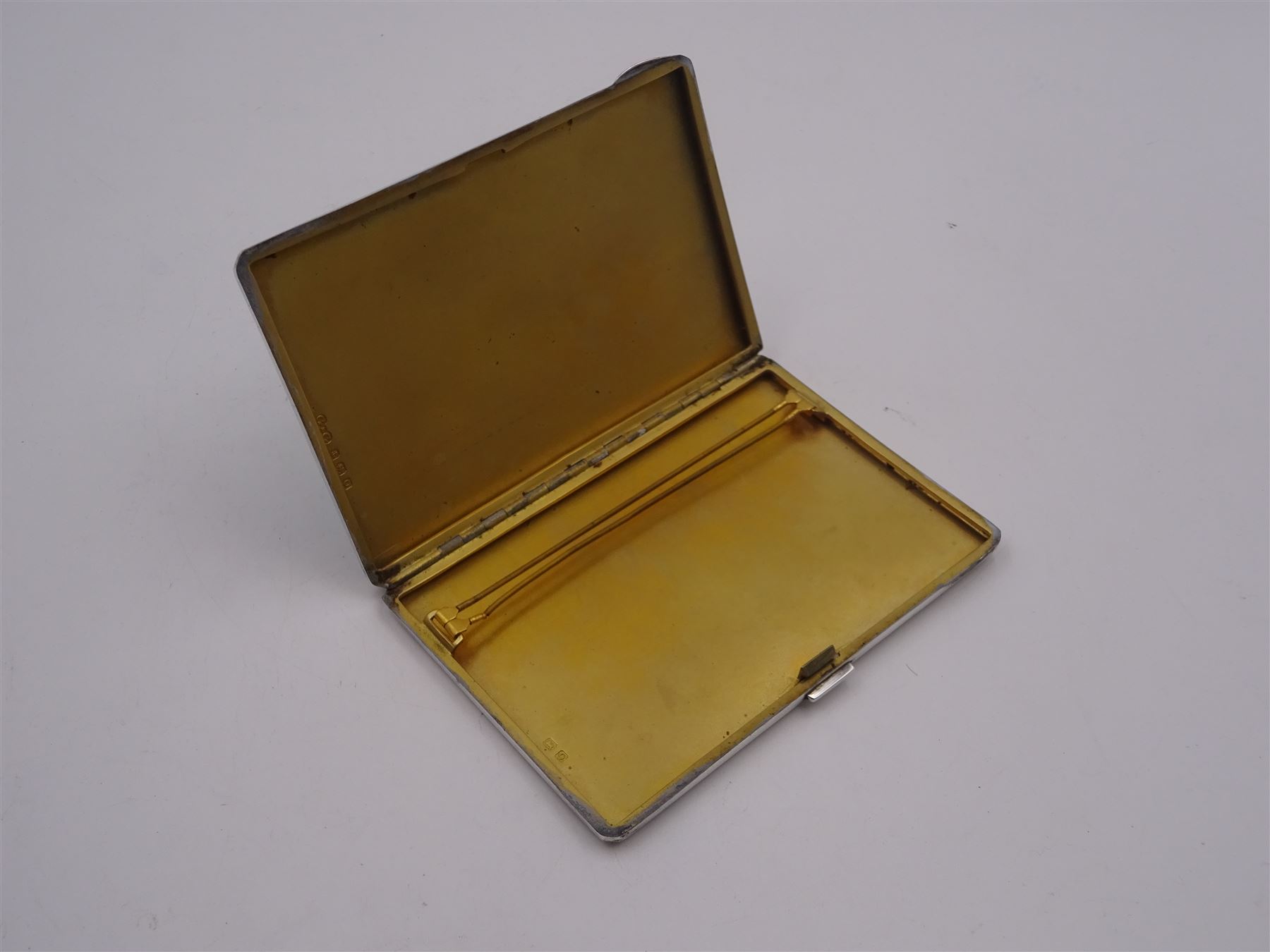 Late Art Deco silver and enamel cigarette case, with green guilloche enamelled front, engine turned detail verso, and gilt interior, hallmarked G & G, Birmingham 1938, H12.5cm, approximate gross weight 7.75 ozt (241.1 grams)