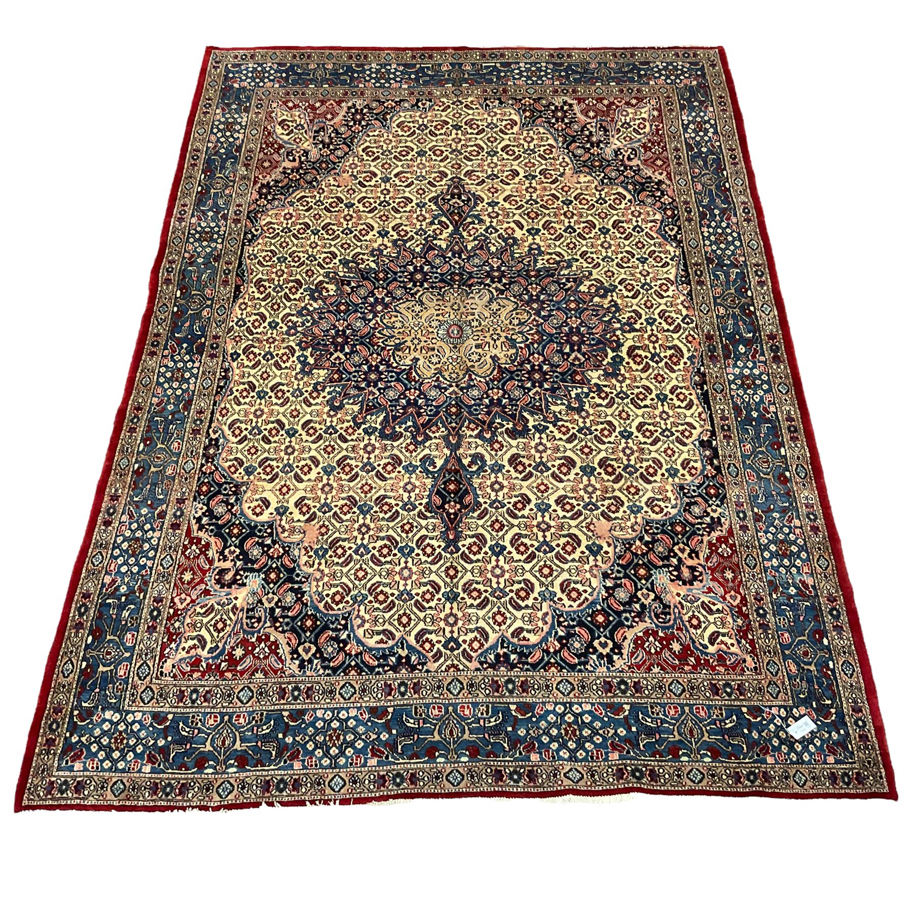 Persian Moud carpet, the field decorated all-over with Herati motifs, central medallion and spandrels decorated with stylised plant and flower head motifs, repeating border with guard