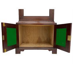 Mahogany display cabinet with hidden compartment, projecting cornice over single glazed door enclosing glass shelves, double panelled cupboard below, the interior with button releasing sliding back compartment, on bracket feet