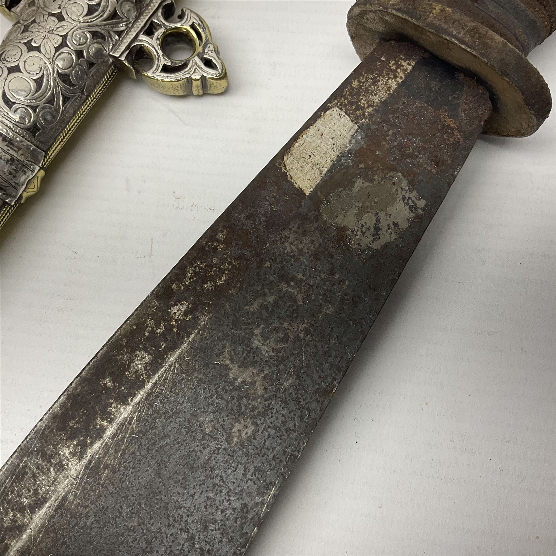 Moroccan jambiya dagger with 24.5cm plain curved blade stamped LONDON to the ricasso area, the hilt and scabbard overlaid with plain sheet brass to the back and ornate silver coloured metal to the front; waisted grip and arched pommel; two pyramid mounts to the scabbard L41cm overall; large billhook with curving blade and stacked leather washer grip; and a reproduction halberd blade (3)