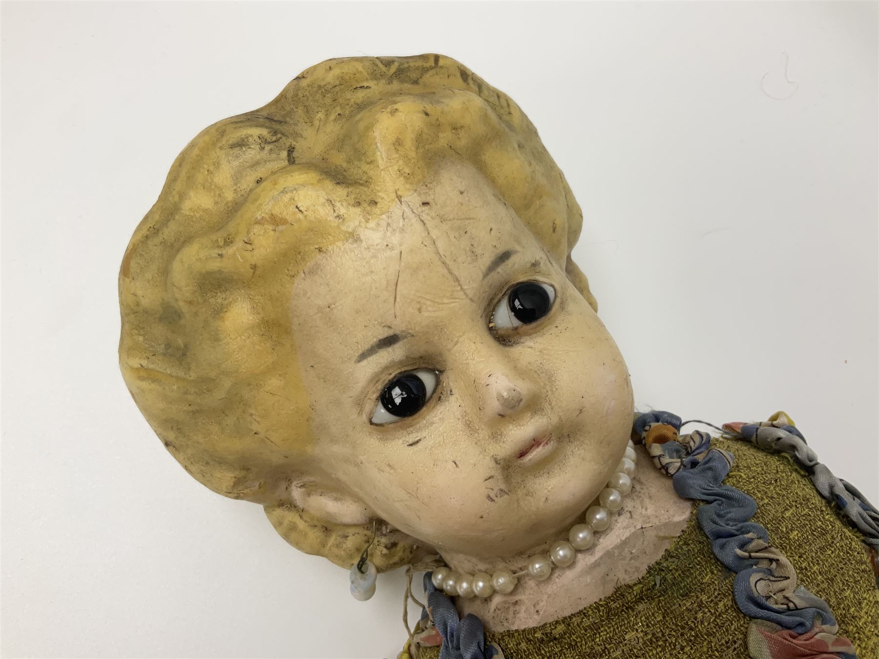 Victorian large wax over composition Pumpkin head doll, with inset dark glass eyes, moulded blonde hair in curls, stuffed body with carved and painted wooden limbs, grey painted boots, floral satin dress with netting underclothes H61cm