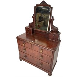 Victorian scumbled pine dressing chest, raised swing mirror in moulded frame with scrolled carved pediment, foliage S-scroll carved supports over trinket drawers, moulded rectangular top with rounded corners over two short and two long drawers, skirted base on turned feet, scumbled to resemble mahogany 