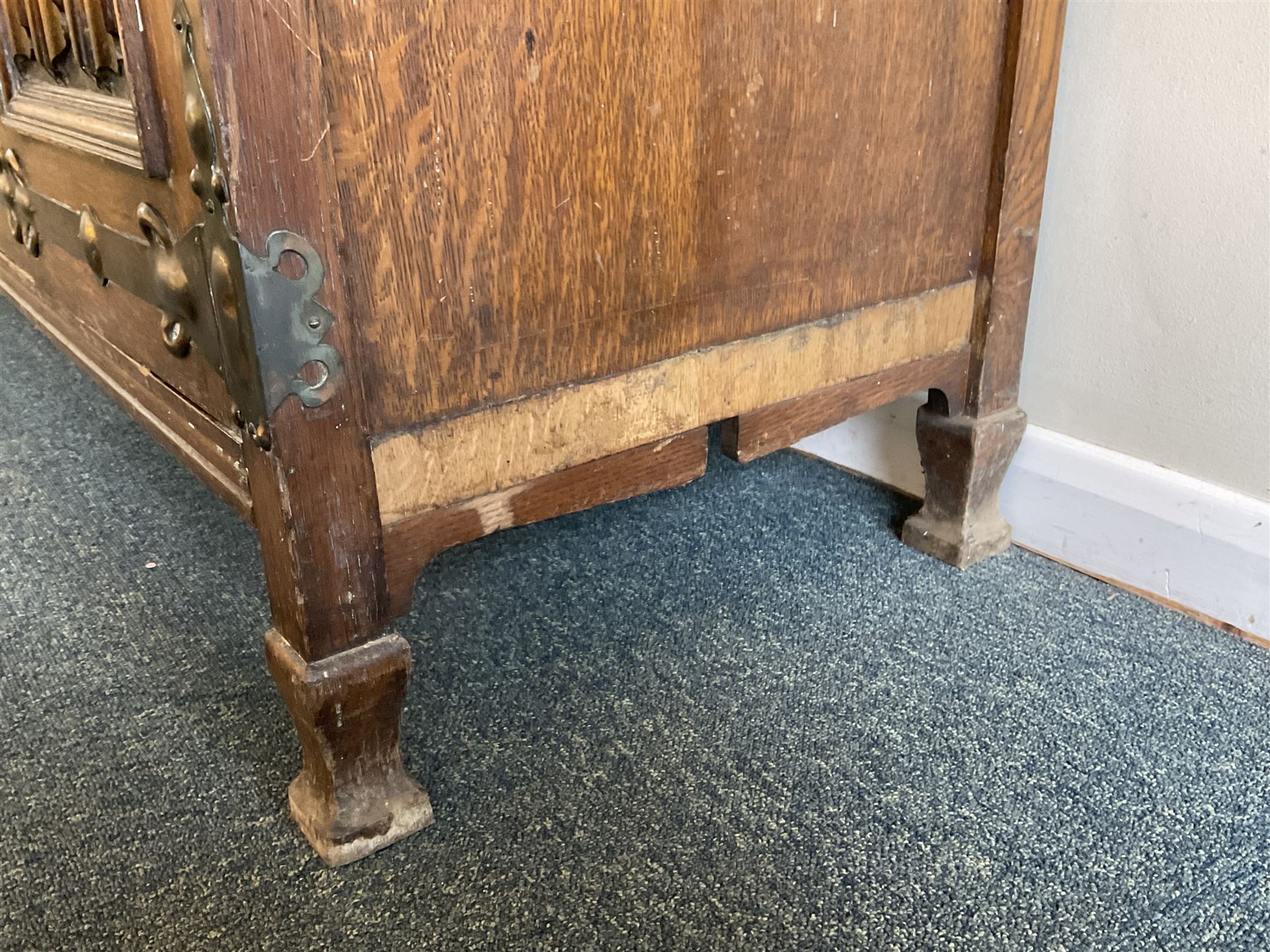 Shapland and Petter - Arts & Crafts period oak dresser, raised gallery top with spade balustrade, central bevelled mirror flanked by two cabinet, astragal glazed doors with yellow tinted glass and bullseye panes, the sides with pierced heart shaped decoration, fitted with two drawers and two double cupboards, enclosed by linenfold panelled doors,  copper work strap hinges and fixtures, on shaped spade feet, the locks stamped 'S&P'