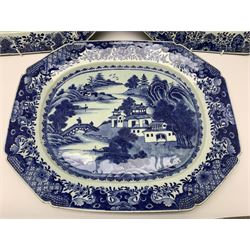 Three late 18th/early 19th century Chinese export blue and white platters, of canted form, decorated with various landscapes set with typical motifs including pagodas, bridges, and islands, within spearhead and cell diaper and foliate borders, largest example W46.5cm 