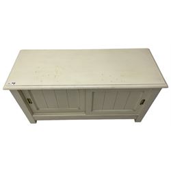 Cream finish low side cabinet, moulded rectangular top over two sliding panelled doors, on stile supports 