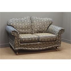  Pair two seat traditional style sofas with mahogany feet on brass castors, floral pattern upholstery (W158cm) and matching footstool  