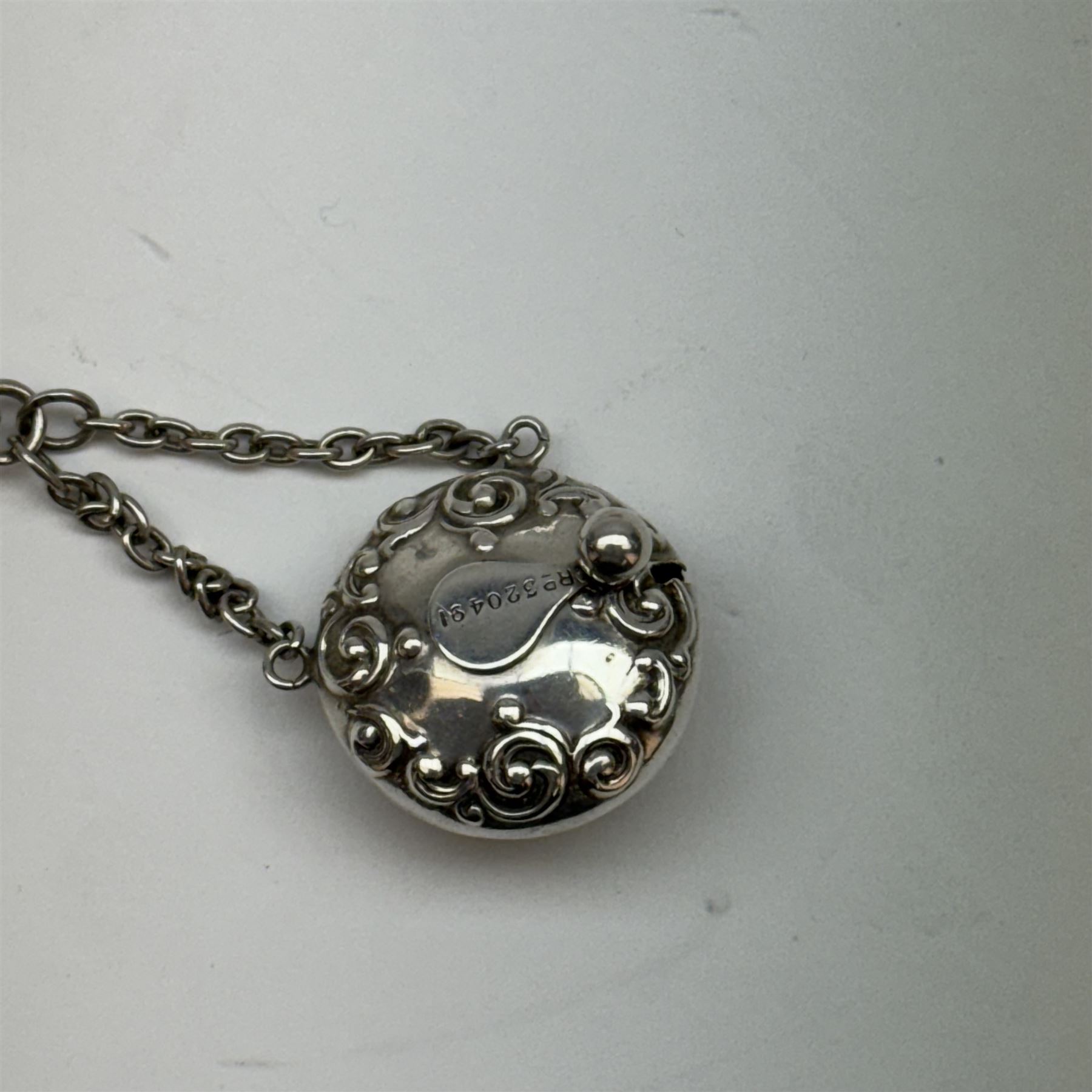 Victorian and later silver chatelaine, the shaped and foliate pierced clasp with embossed oval panel of a courting couple, hallmarked Levi & Salaman, Birmingham 1899, supporting six accessories on five chains: a circular mirror embossed with putti, hallmarked Henry Matthews, Birmingham 1911, pencil holder engraved with foliate scrolls, hallmarked Francis Webb, Birmingham 1914, conical scent bottle decorated with bamboo, (unmarked but testing as silver), aide memoire embossed with putti, hallmarked Samuel M Levi, Birmingham 1911, tape measure of compressed spherical form, hallmarked Henry Matthews, Birmingham 1899, and a purse with embossed putti, hallmarked Birmingham 1909, makers mark worn and indistinct, at longest point L31cm

