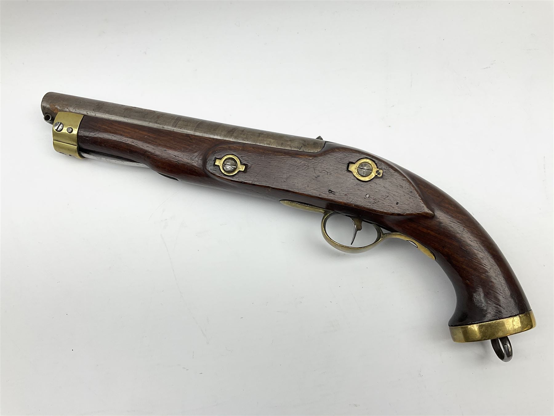 Early 19th century percussion cap cavalry pistol with round 23cm unsighted barrel, borderline engraved action lock (lacking hammer), walnut full stock with heavy brass furniture, iron lanyard ring to the flat butt cap and long flat retaining spring below fore-end for captive ramrod (missing) L41cm overall