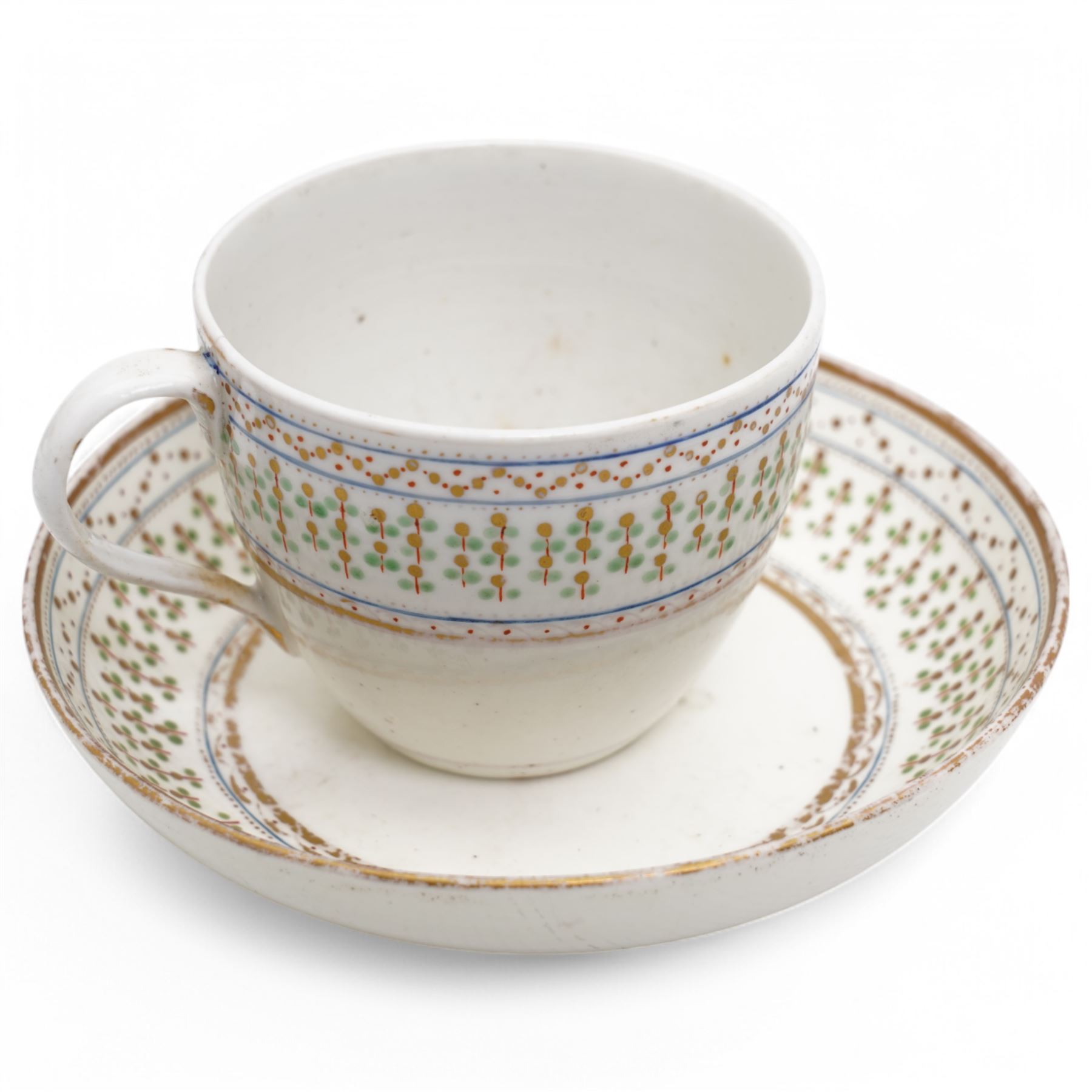 Pinxton porcelain trio, pattern no.193, comprising coffee can, teacup and saucer, decorated with green and gilt stylised sprigs and red and gilt dot borders, teacup with painted marks to base (3)