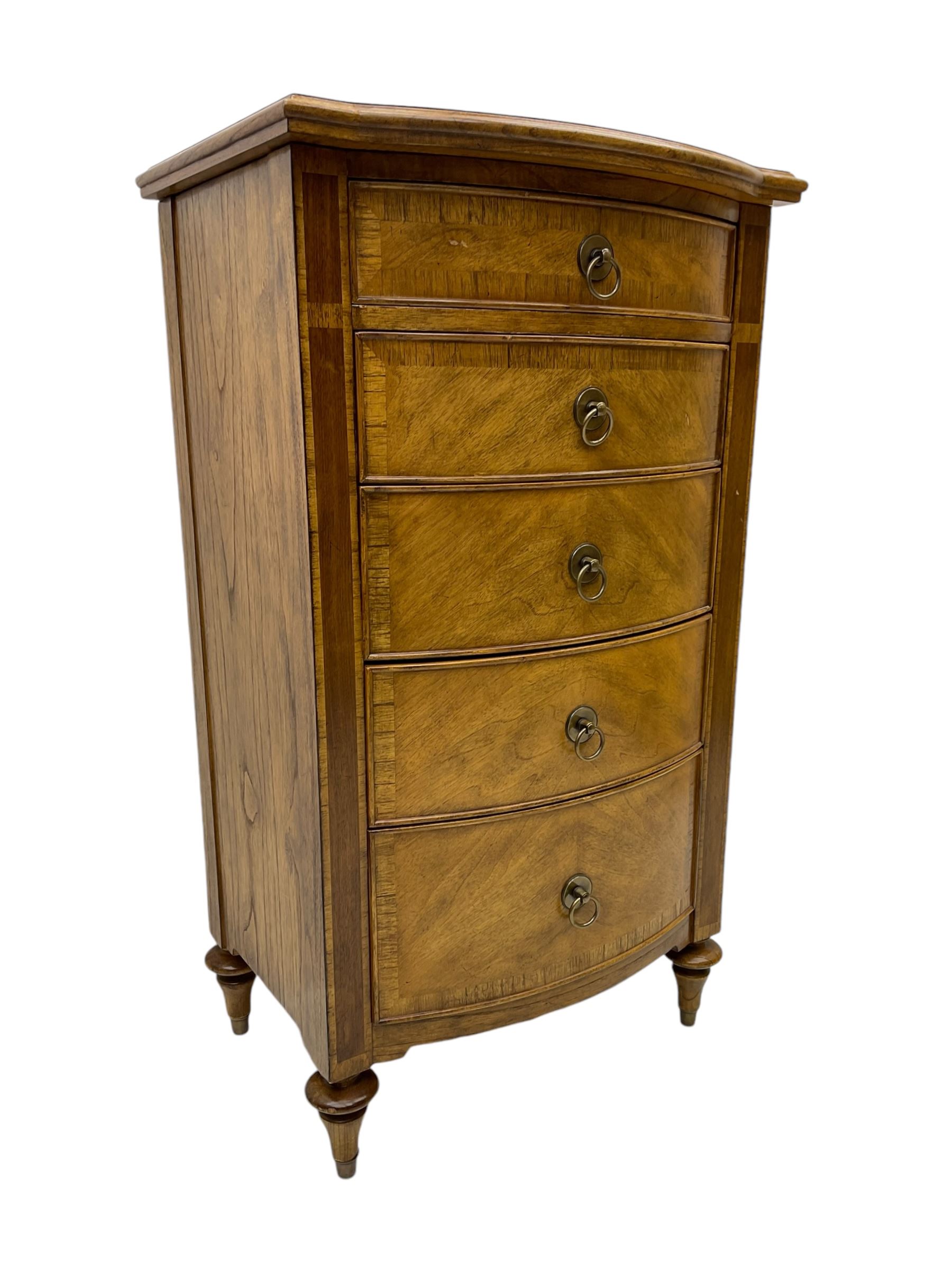 Frank Hudson - mid-20th century Mindi ash and burr walnut bow-fronted lingerie chest, crossbanded hinged top concealing vanity mirror, over five graduated cockbeaded drawers, raised on turned supports