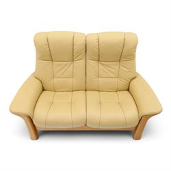Ekornes Stressless - beech framed reclining two seater sofa, out-swept arms over tapering supports, upholstered in beige leather