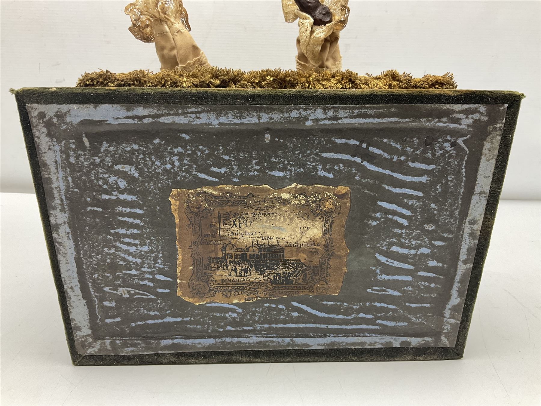 Modern reproduction automaton in the form of a baby doll in a basket clothed in Victorian style lace bloomers and frilled bonnet; clockwork action; on raised platform; with French paper label on base, 29cm wide,