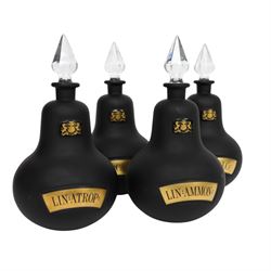 Set of four 20th century Royal Pharmaceutical Society black frosted glass bottles, of bellied form with clear cut glass spire stopper, each body bearing gilt label in Latin: LIN:AMMON:, LIN:ATROP:, LIN:CAMPH:, and LIN:CALCi:, and gilt Royal Pharmaceutical Society crest to neck, H25cm

Provenance: From the collection of the family of Peter Green, a practising pharmacist whose career spanned the mid to late 20th century. During his professional life he managed pharmacies in Yeovil, Somerset, and later Selles Chemist in Filey, North Yorkshire, before purchasing and running his own business, Peter Green Pharmacy, located in the Market Place, Malton. The bottles were displayed as part of the traditional shop fittings in both the Filey and Malton pharmacies and were retained as part of his collection.