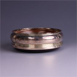 Modern silver mounted bottle coaster, with turned wooden base, hallmarked Carrs of Sheffield Ltd, Sheffield 2003 and a Victorian silver inkwell stand, hallmarks worn and indistinct, coaster D10cm