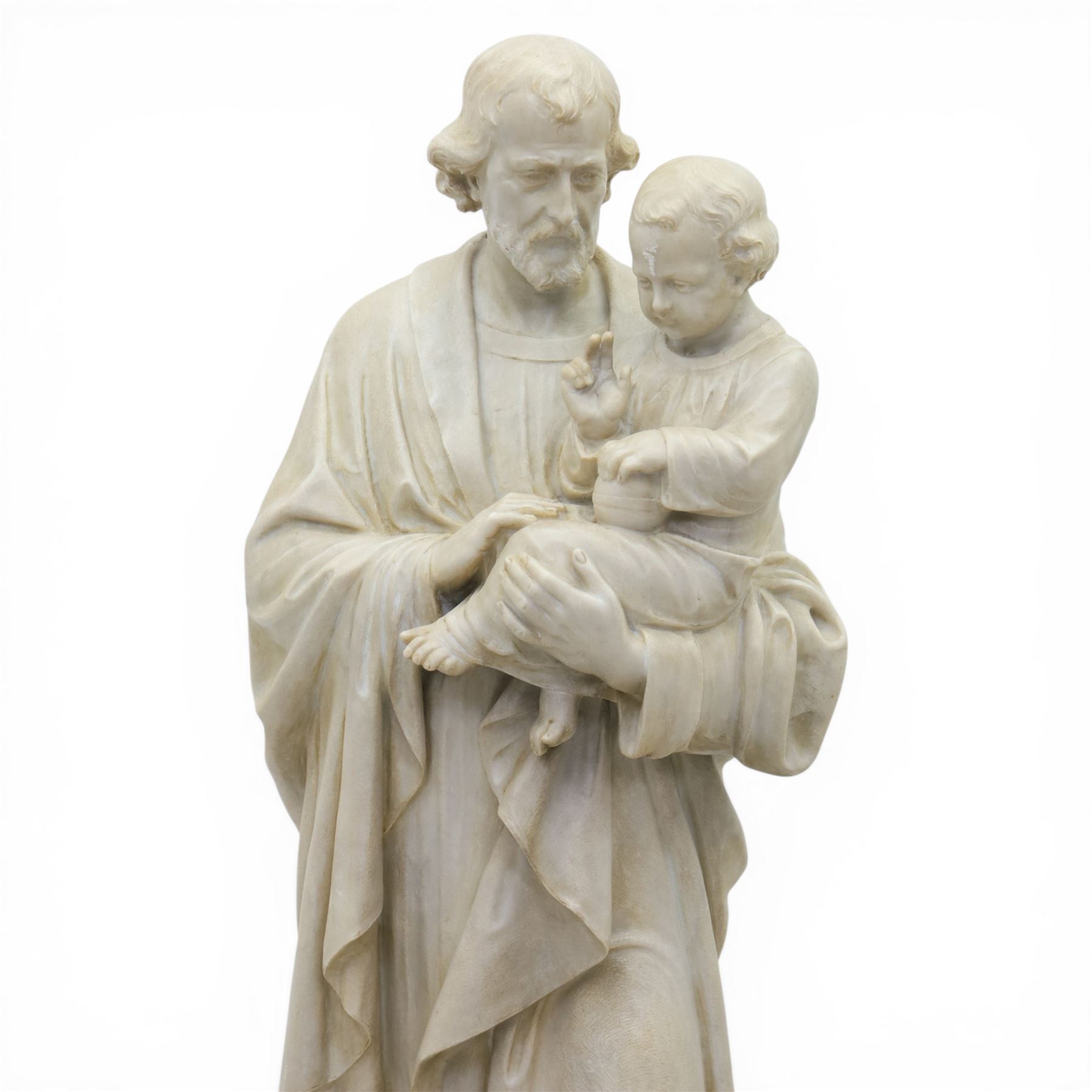 Carved stone and alabaster figure group of Saint Joseph and the Christ Child, modelled standing holding the infant, draped in flowing robes, raised on square plinth base