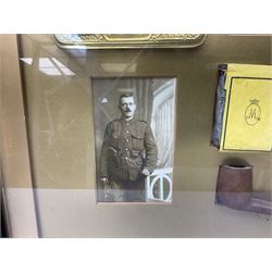 Framed display of a Princess Mary 1914 Christmas tin with greeting card, two pictures of the Princess, original packet of tobacco, smoking pipe and photograph of the recipient in uniform 38 x 47cm; ebonised and gilt frame