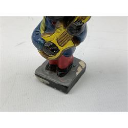 Robinson Jam plaster Golly band, including drummer and singer, H7.5cm

Originally handmade by mothers in Africa for their children from old fabric and cloth, the golly doll was adopted as the mascot and trademark for the Robertson's confectionery brand around 1910 after the company's founder John Robertson visited the US and noticed children playing with them. Robertson's Gollies have been collected by people across the UK and around the world for generations but garnered a contentious image in the 1980s because of links to racism. The trademark was removed from Robertson's branding in 2001.