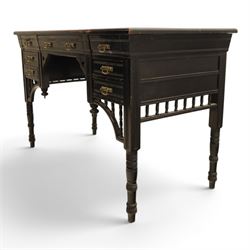 Victorian Aesthetic Movement ebonised writing desk, rectangular top with inset tooled leather, central frieze drawer with pierced spandrels, flanked by two banks of three drawers, brass swing handles, raised on turned supports 