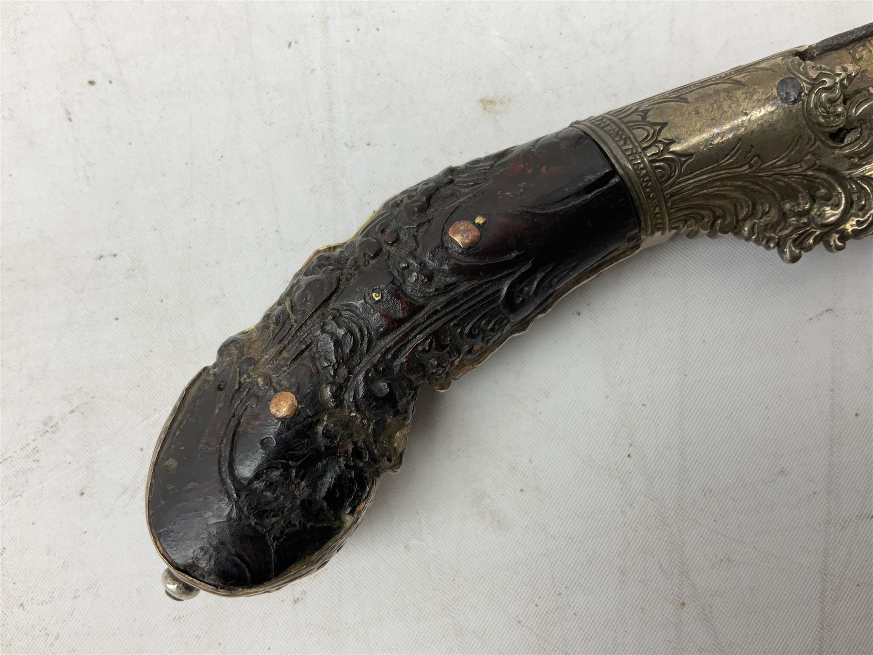 19th century Singhalese knife pia kaetta, the 20cm steel blade inset with yellow and white metal, with metal mounted carved pistol grip, in plain wooden scabbard L33cm overall