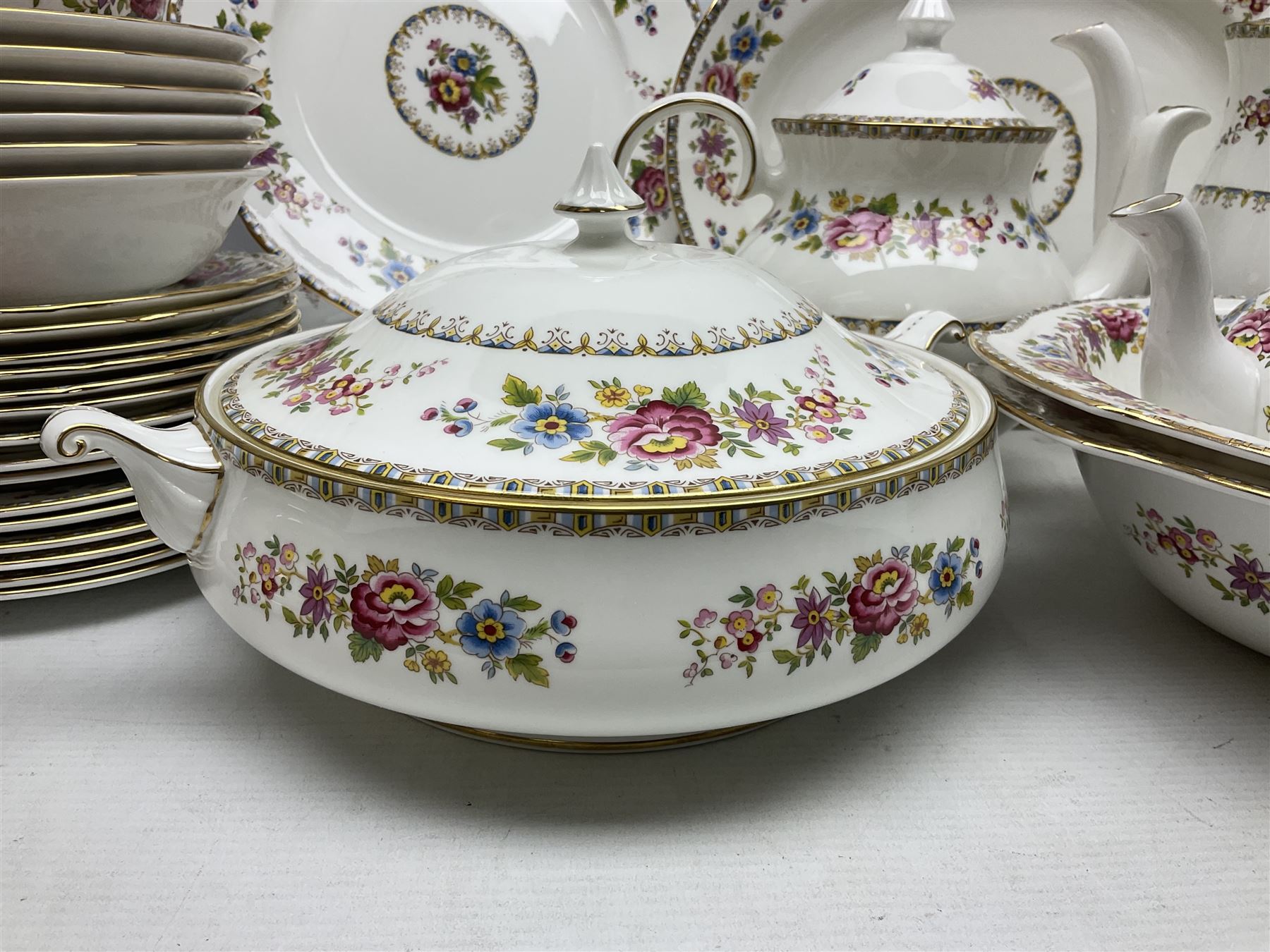 Extensive Royal Grafton Malvern pattern tea and dinner wares, comprising twelve dinner plates, six smaller plates, coffee pot, two teapots, two cake plates, eight teacups and ten saucers, six coffee cups and six saucers, two open sucriers, twin handled lidded sucrier, jug, lidded mustard pot and condiment jar, lidded tureen, two circular twin handled vegetable tureens, sauce boat and stand, oval and circular serving plates, salt and pepper shakers, breakfast cup and two saucers, further large cup and saucer, eighteen tea plates of various shapes, six side plates, six cereal bowls and six further bowls, shell dish and dish of square form, fork and knife, together with a hallmarked silver condiment spoon