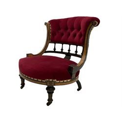 Victorian ebonised and amboyna nursing chair, the curved serpentine upright supports joined by balustrade, upholstered seat and buttoned back in claret fabric, turned and fluted supports with ceramic castors 