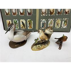 Three ceramic bird figures comprising Royal Crown Derby thrush chicks, Albany Royal Worcester crested grebe and a Goebel robin, along with 'British Birds' and 'Birds Eggs' Ogden's cigarette cards housed in an album