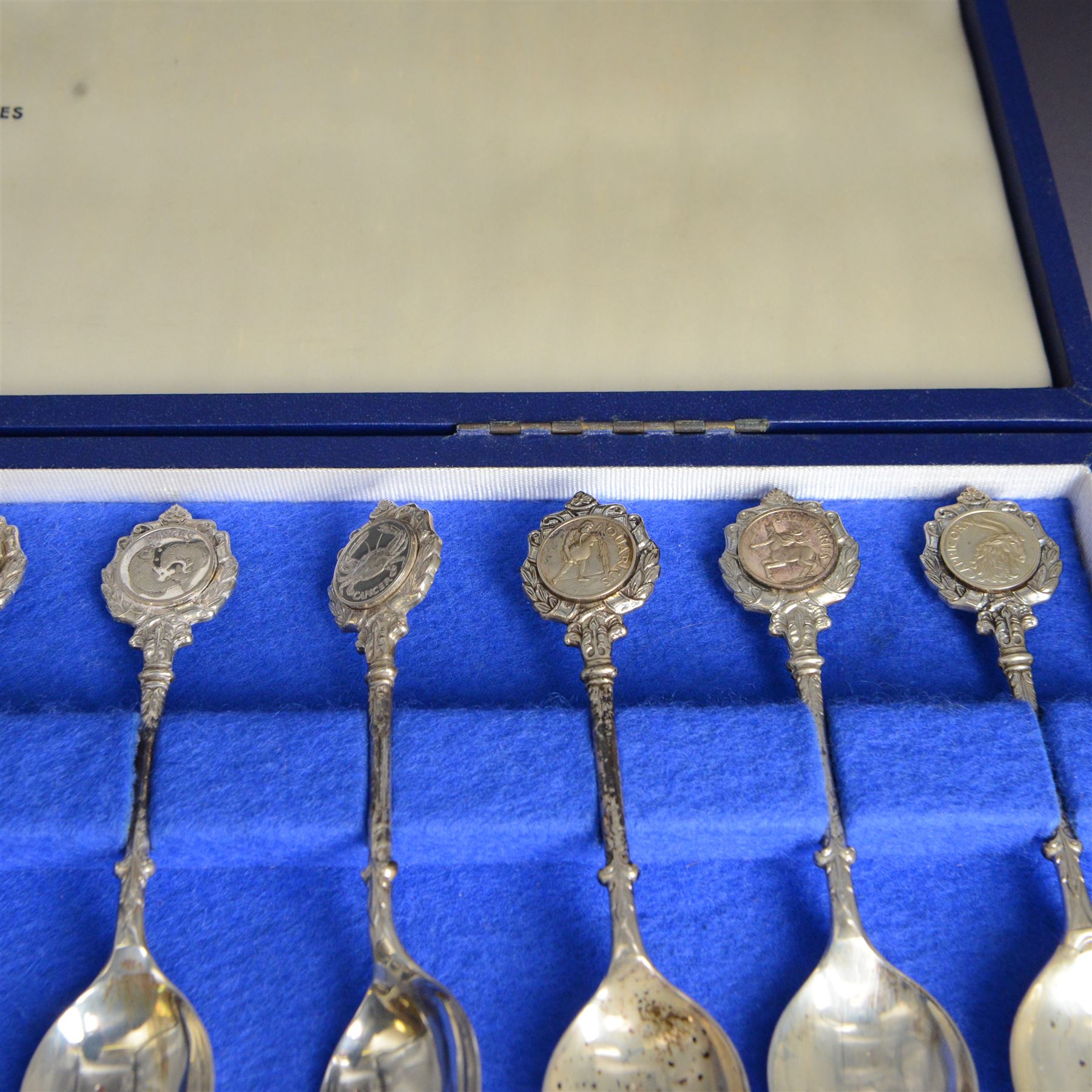 Set of twelve modern silver teaspoons 'The Twelve Zodiac Spoons', all decorated with symbols of the zodiac, hallmarked John Pinches, London 1971, contained within fitted case