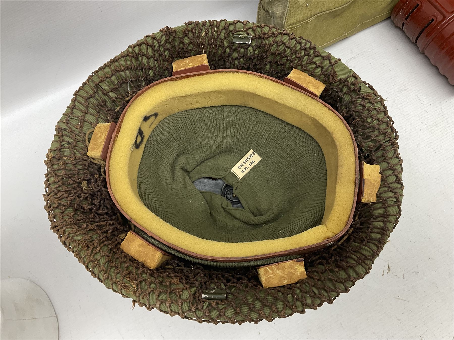 1970s British turtle style steel helmet with liner, green cover and netting; liner marked C.W.L. 1972 No.8415-99-973-6750; size 6 3/4 - 6 7/8; WWII respirator dated 1941 in canvas carrying case; and a Native long-shafted spear with iron head and bound plain round haft L165cm (3)