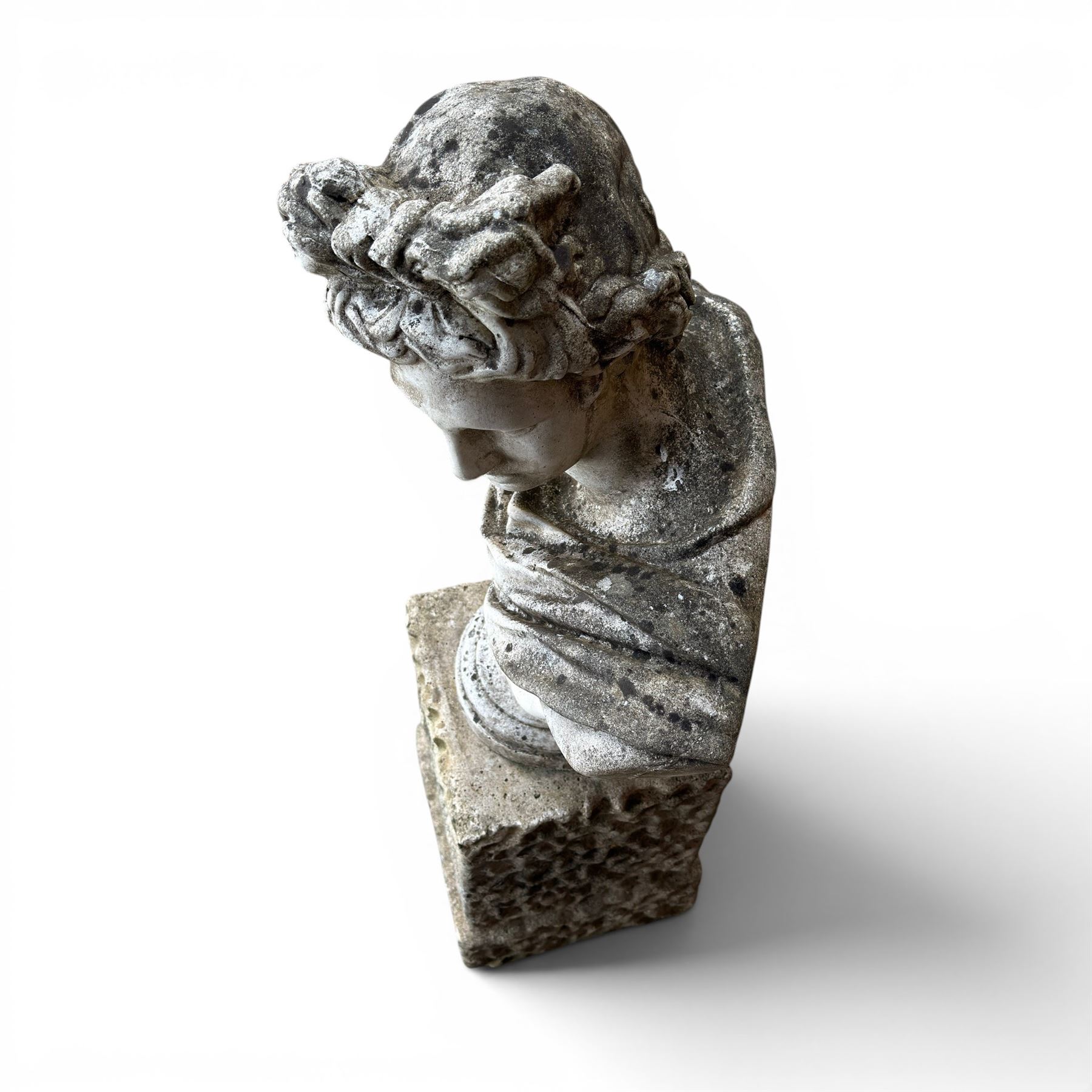 Roman Neoclassical style cast stone bust, weathered finish, raised on textured stone plinth of tapering form