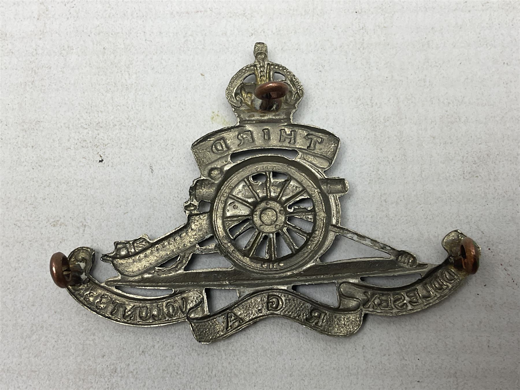 Third Middlesex Royal Garrison Artillery Volunteers Cap Badge, white meta Royal Artillery cap badge with “THIRD” to the top scroll and lower three part scroll “MIDDLESEX – R.G.A. – VOLUNTEERS”. Three lug fittings to the reverse.