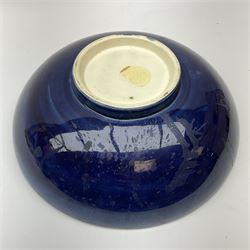 Moorcroft footed bowl, decorated in Hibiscus pattern upon a dark blue ground, with impressed marks and remnants of paper label beneath, D26cm. 