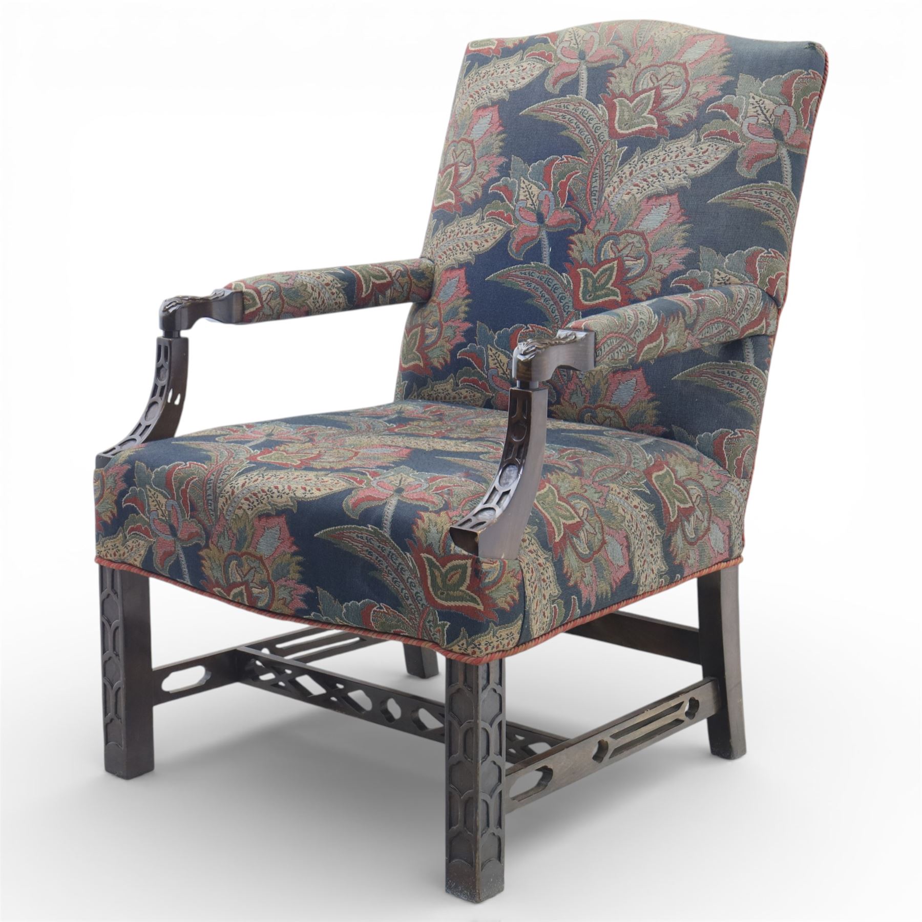 Early 20th century Chippendale revival Gainsborough elbow chair, rectangular upholstered back and seat covered in foliate patterned fabric, with open arms carved to the terminals and supports with pierced and geometric detail, raised on square section legs with blind fretwork panels