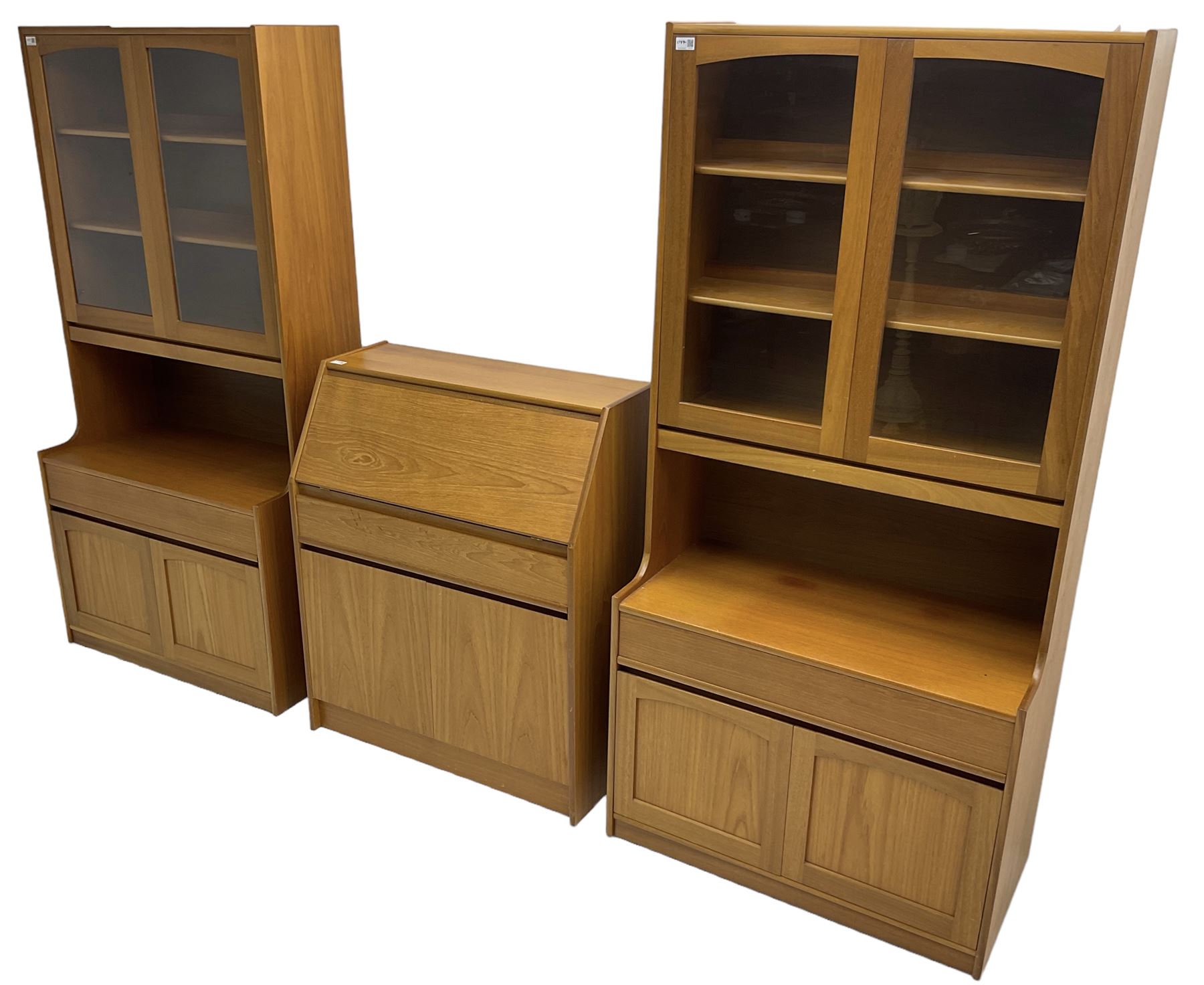 Sutcliffe of Todmorden - pair of teak wall units, fitted with two glazed doors over drawer and double cupboard (W86cm, D45cm, H198cm); and a matching fall front bureau (W84cm, D41cm, H100cm)