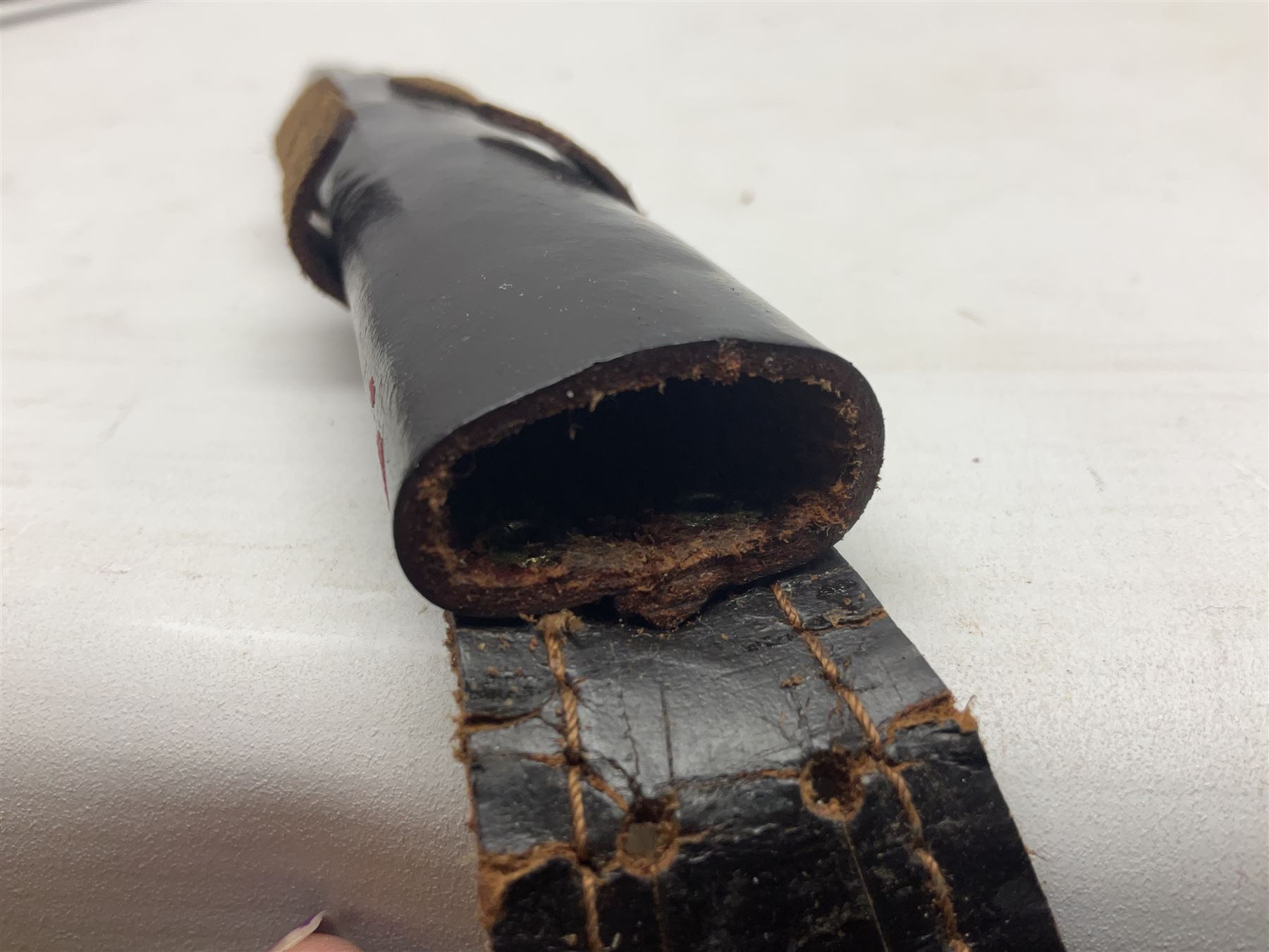 Third Pattern Commando Knife or Dagger with 17.5cm flattened diamond section blade and regulation black painted ribbed copper hilt with brass pommel nut; stamped William Rodgers Sheffield England to the cross-piece; in black painted brass mounted leather scabbard L34.5cm overall