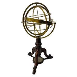 19th century brass terrestrial armillary sphere on rosewood base, lobe carved column on three splayed supports with scrolled carved terminals, the supports united by circular compass with turned stretchers