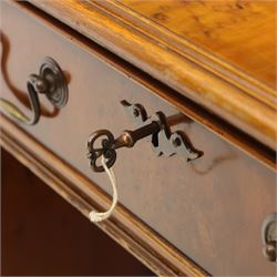 Late 20th century yew wood nine drawer writing desk, rectangular top inset with gilt-tooled green leather, above an arrangement of nine drawers with brass swan-neck handles, raised on bracket feet