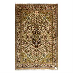 Fine Qom hand-knotted rug, ivory ground, with a dark navy shaped floral medallion and pend...