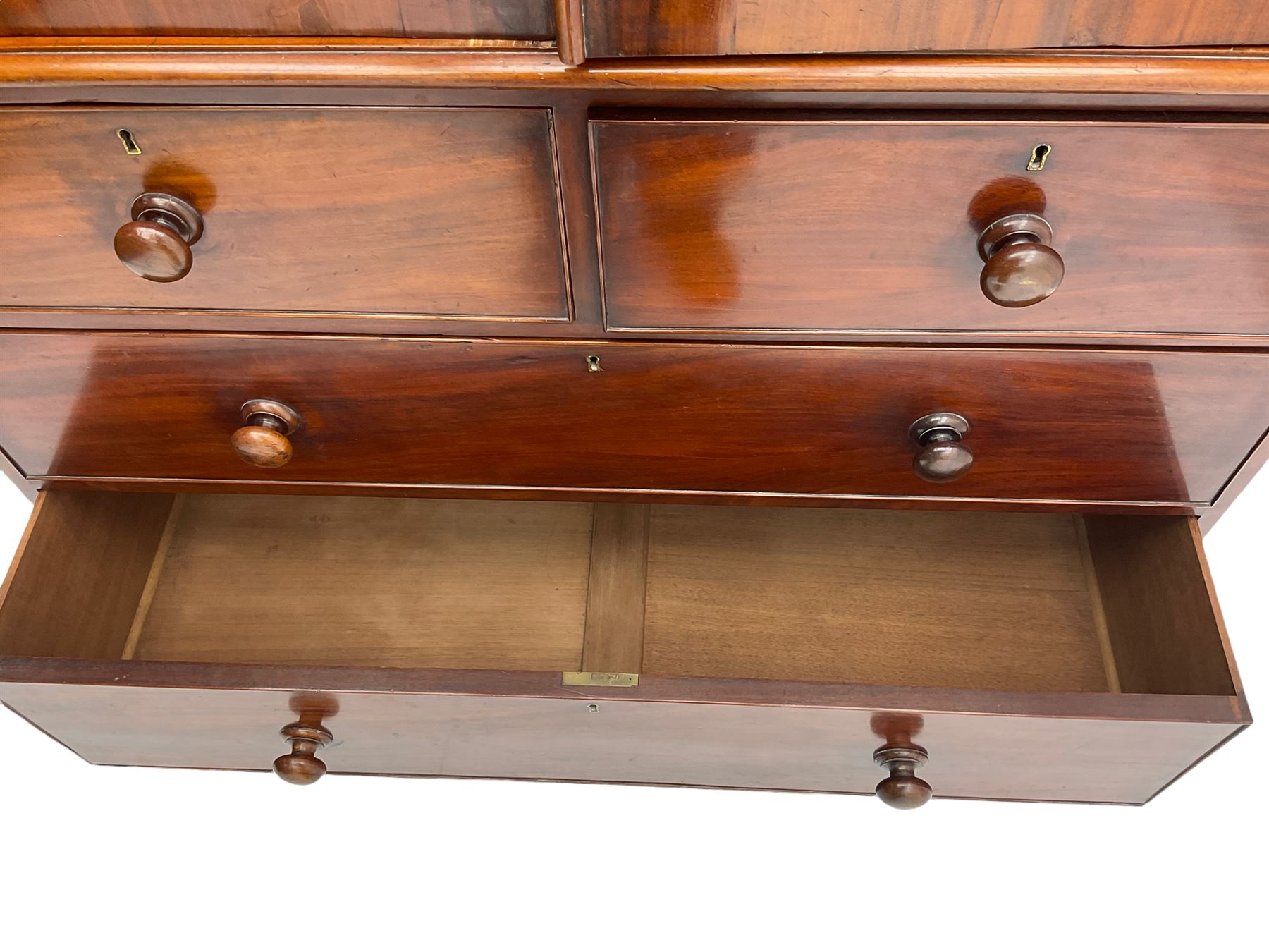 Victorian mahogany linen press, projecting moulded cornice, two doors with arched panels enclosed four linen slides, the lower section fitted with two short and two long drawers, on plinth base