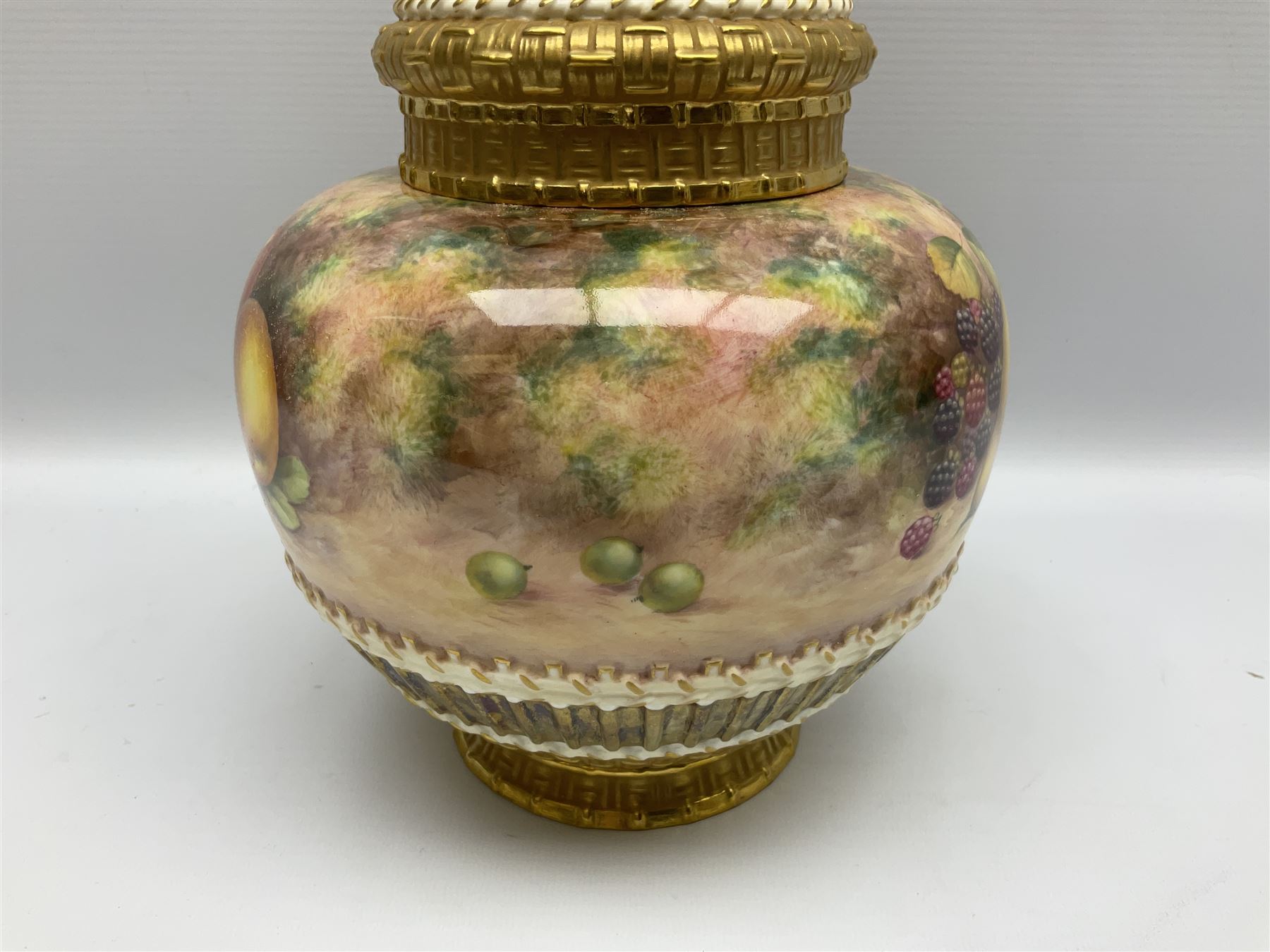Mid 20th century Royal Worcester potpourri vase and cover decorated by Alan Telford, of ovoid form with inner cover and pierced gilt outer cover with bud finial, upon short gilt circular foot, the body part moulded with basket weave bands in gilt and bronze, and hand painted with a still life of fruit upon a mossy ground, signed Telford, with black printed mark beneath and painted shape number 1286, H25.5cm