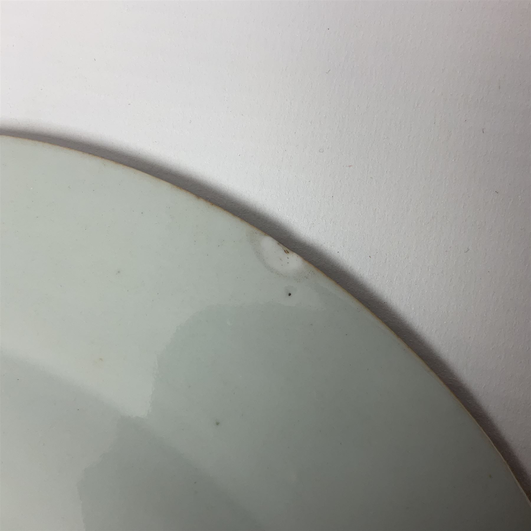 Three 18th century Chinese Famille Rose plates, the first example enamelled with blossoming peonies, rockwork and fence, the other two examples of similar design, decorated with blossoming peonies and sprigs within shaped inner borders, each approximately D23cm