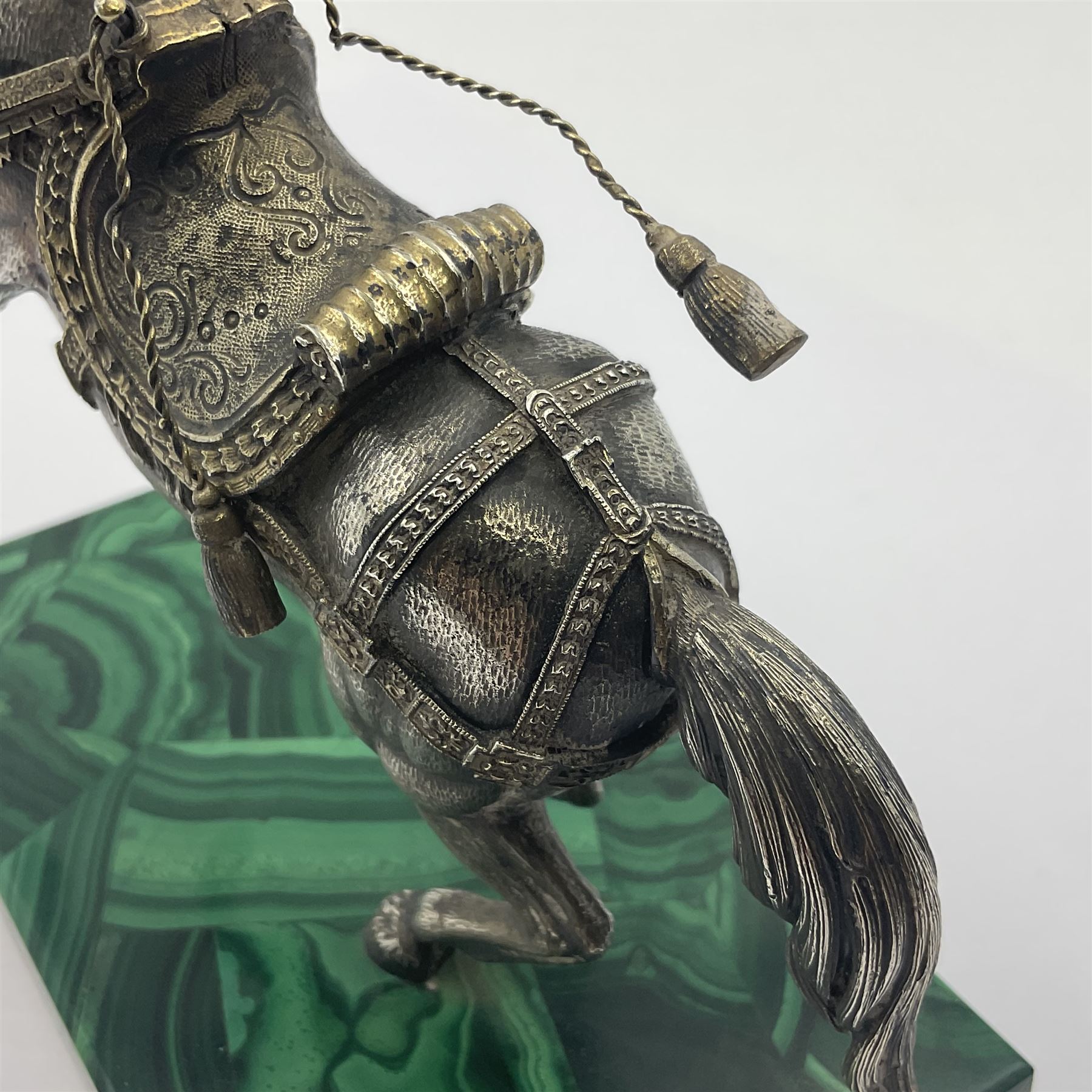 Modern silver model of a rearing horse, with ornate parcel gilt saddle and bridle, mounted upon a rectangular base, decorated with malachite panels to each side and upon four gilt bun feet, horse stamped 925, overall H14.5cm